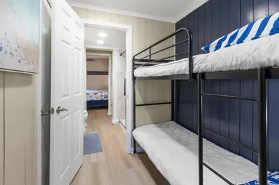 a room with two bunk beds and a hallway at K and J Panama City Beach in Panama City Beach