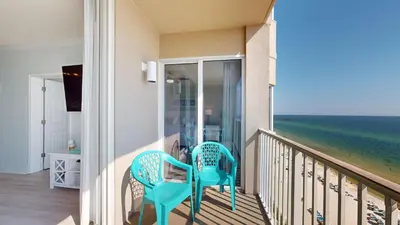 a balcony with two chairs and the ocean at Tidewater 1005 in Panama City Beach