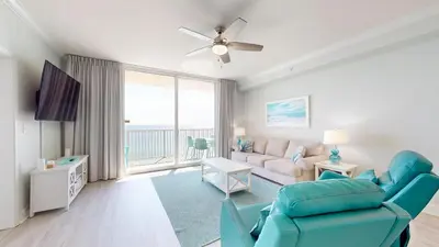 a living room with a couch and a tv at Tidewater 1005 in Panama City Beach