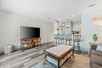 a living room with a flat screen tv and a couch at Nautical Watch #E-7 by Book That Condo in Panama City Beach