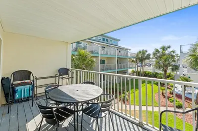 a patio with a table and chairs on a balcony at Nautical Watch #E-7 by Book That Condo in Panama City Beach