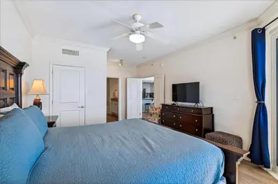 a bedroom with a blue bed and a television at 601 Grandview East in Panama City Beach