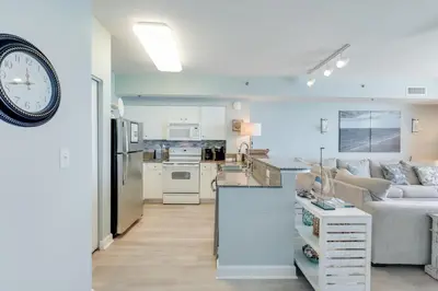a kitchen and living room with a couch and a clock at 930 Shores Of Panama in Panama City Beach