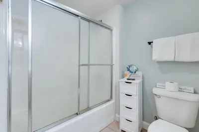 a white bathroom with a shower and a toilet at 930 Shores Of Panama in Panama City Beach