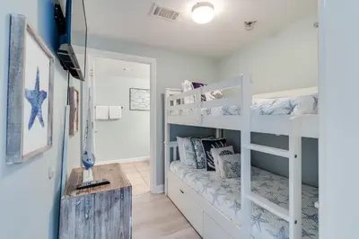 a room with two bunk beds and a desk at 930 Shores Of Panama in Panama City Beach