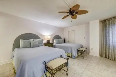 a bedroom with two beds and a ceiling fan at 203 Moondrifter in Panama City Beach
