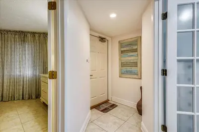 a hallway with a door leading to a bathroom at 203 Moondrifter in Panama City Beach