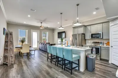 a kitchen and living room with a table and chairs at A Shore Thing- A in Panama City Beach