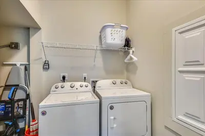 a laundry room with two washing machines and a shelf at A Shore Thing- A in Panama City Beach