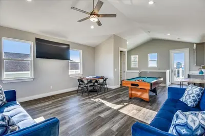 a living room with a blue couch and a pool table at A Shore Thing- A in Panama City Beach