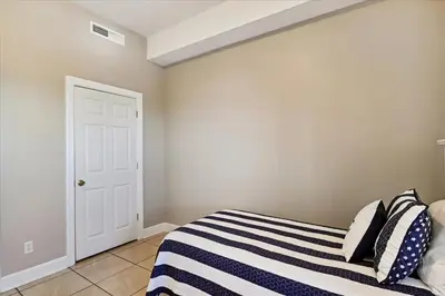 a bedroom with a bed with a blue and white striped blanket at 2102 Ocean Villa in Panama City Beach