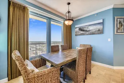 a dining room with a table and chairs and a large window at 1909 Seychelles in Panama City Beach