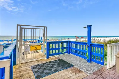 a blue gate to a deck with the beach at 1909 Seychelles in Panama City Beach