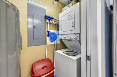 a small room with a washing machine and a red stool at 1409-Seychelles in Panama City Beach