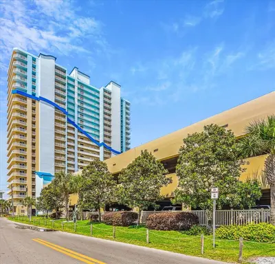 a large building on a street with trees in front at 1409-Seychelles in Panama City Beach