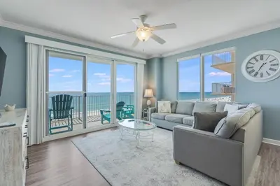 a living room with a couch and a clock at 305 Marisol in Panama City Beach