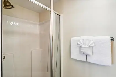 a bathroom with a shower and a towel with a bow at #17 Latitude 29 in Panama City Beach