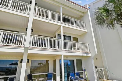 a large white building with chairs and a balcony at #17 Latitude 29 in Panama City Beach