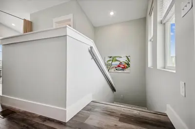 a staircase in a room with white walls and wood floors at Starfish Shores in Panama City Beach