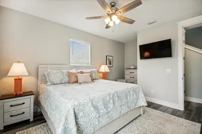 a bedroom with a bed and a ceiling fan at Starfish Shores in Panama City Beach