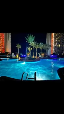 a large swimming pool with palm trees at night at 225-Shores Of Panama in Panama City Beach