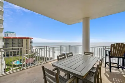 a table and chairs on a balcony with a view of the ocean at 701 Sterling Beach in Panama City Beach