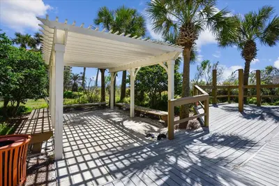 a white gazebo on a patio with palm trees at 701 Sterling Beach in Panama City Beach