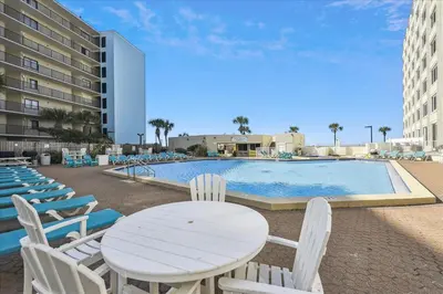 a table and chairs next to a swimming pool at 721 Top Of The Gulf in Panama City Beach