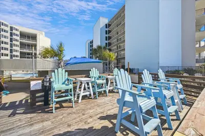 a group of blue chairs and tables on a deck at 721 Top Of The Gulf in Panama City Beach