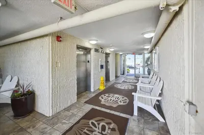 a hallway with white chairs and a hallway with a hallway at 721 Top Of The Gulf in Panama City Beach