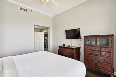a bedroom with a bed and a dresser and a tv at 1504 Sterling Beach in Panama City Beach
