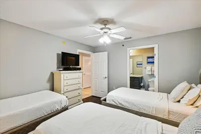 a bedroom with two beds and a ceiling fan at 1504 Sterling Beach in Panama City Beach
