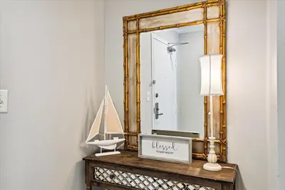a mirror on top of a wooden table with a clock at 1504 Sterling Beach in Panama City Beach