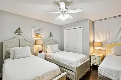 a bedroom with two beds and a ceiling fan at 1504 Sterling Beach in Panama City Beach