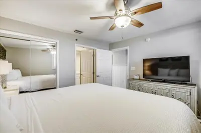 a bedroom with a white bed and a ceiling fan at 302 Sterling Beach in Panama City Beach