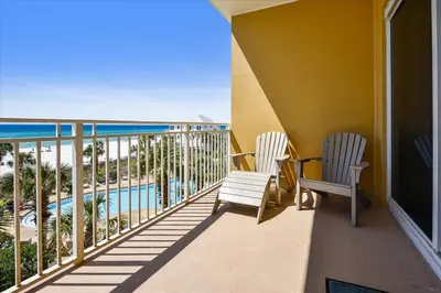 a balcony with two chairs and a view of the ocean at 302 Sterling Beach in Panama City Beach