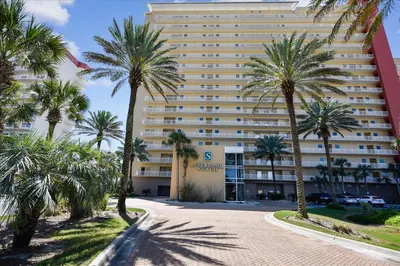 a large building with palm trees in front of it at 302 Sterling Beach in Panama City Beach