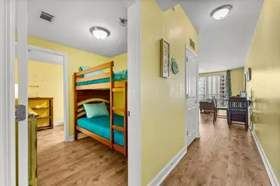 a bedroom with a bunk bed and a dining room at Shores of Panama #1027 by Nautical Properties in Panama City Beach