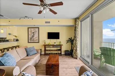 a living room with a couch and a tv at Shores of Panama #1027 by Nautical Properties in Panama City Beach