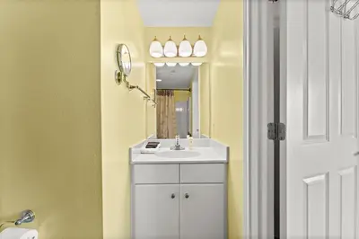 a bathroom with a white sink and a mirror at Shores of Panama #1027 by Nautical Properties in Panama City Beach