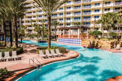 a resort swimming pool with chairs and a building at Shores of Panama #1027 by Nautical Properties in Panama City Beach
