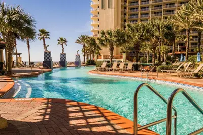 a swimming pool at a resort with palm trees at Shores of Panama #1027 by Nautical Properties in Panama City Beach