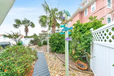 a walkway in front of a house with a fence at Blue Turtle Beach House by Emerald Coast Retreats in Panama City Beach