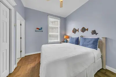 a bedroom with a large white bed with blue pillows at Blue Turtle Beach House by Emerald Coast Retreats in Panama City Beach