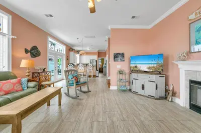 a living room with a couch and a tv at Blue Turtle Beach House by Emerald Coast Retreats in Panama City Beach
