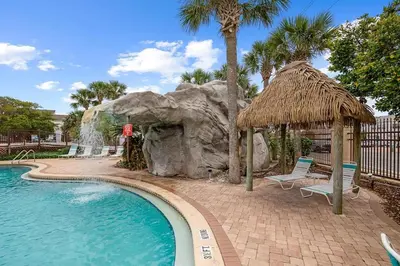 a swimming pool with a waterfall in a resort at Portside 2SG- Seabreeze Townhome by Emerald Coast Retreats in Panama City Beach
