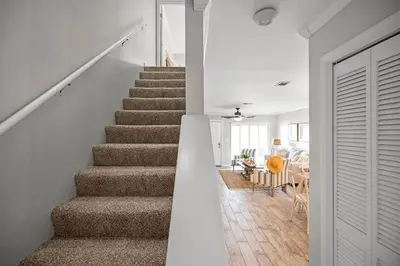 a stairway leading to a living room and a dining room at Portside 2SG- Seabreeze Townhome by Emerald Coast Retreats in Panama City Beach