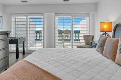 a bedroom with a bed and a desk and windows at Largo Mar 106 by Emerald Coast Retreats in Panama City Beach
