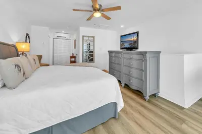 a bedroom with a bed and a dresser with a television at Largo Mar 106 by Emerald Coast Retreats in Panama City Beach