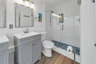 a white bathroom with a toilet and a shower at Largo Mar 106 by Emerald Coast Retreats in Panama City Beach